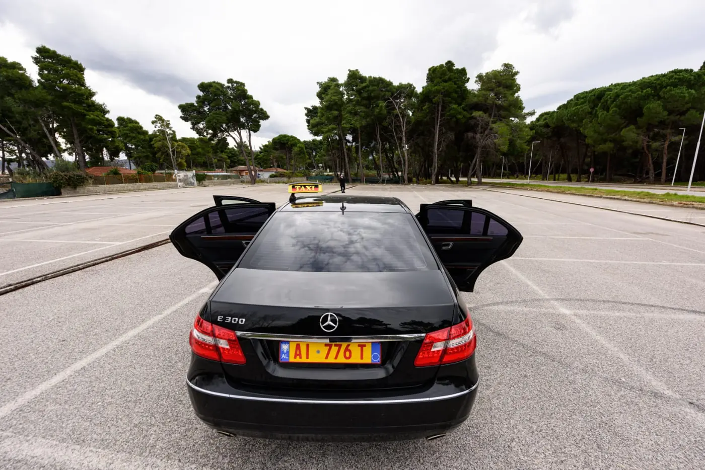 The Dhermi Taxi Mercedes-Benz E-Class with both rear doors open, ready for passengers