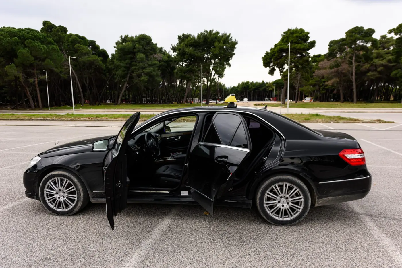 Side view of the black Mercedes-Benz E-Class taxi with its yellow roof sign